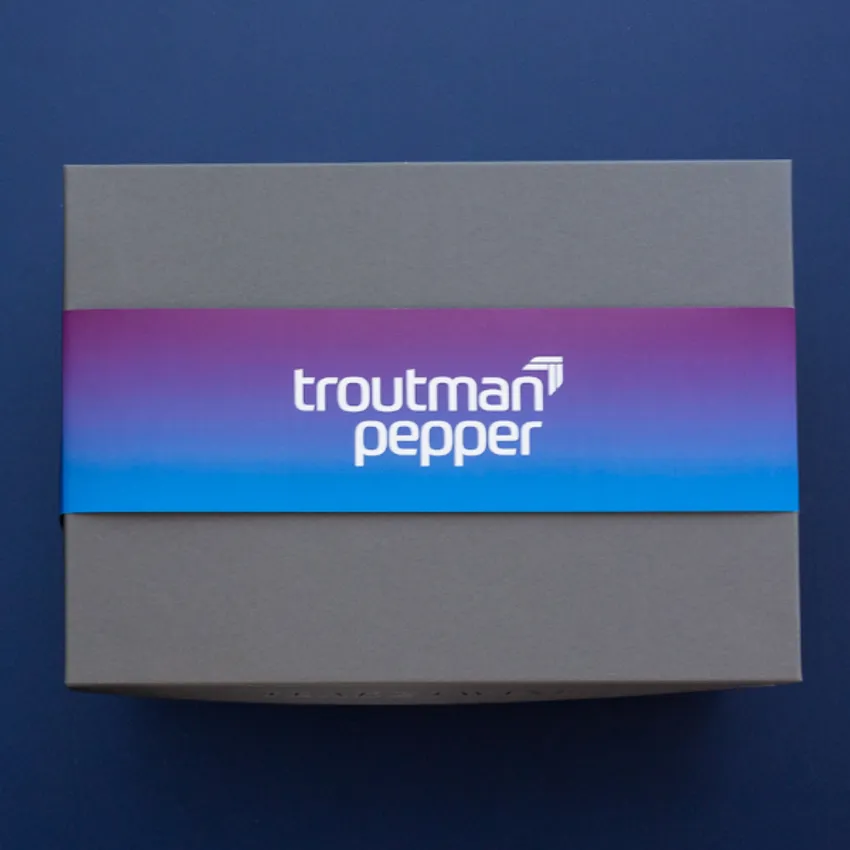 Beautiful box with custom branded belly band for Troutman Pepper on a solid dark blue background