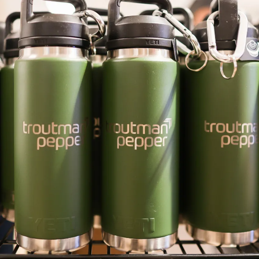 Custom branded Yeti water bottles for Troutman Pepper lined up on an inventory shelf